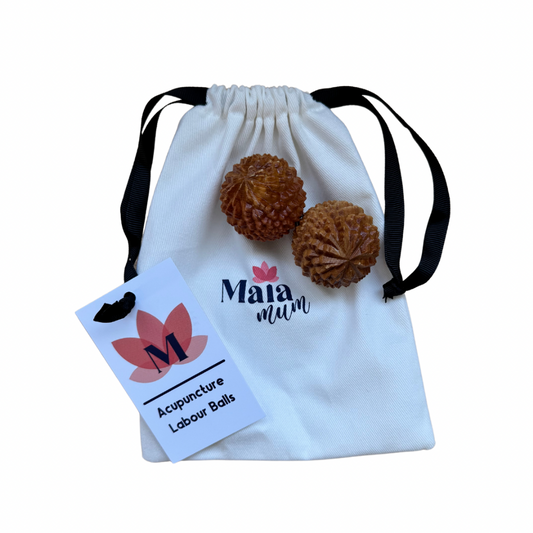 Two wooden acupuncture labour balls with a textured surface, placed in a white drawstring bag, with a card that reads 'Acupuncture Labour Balls'.