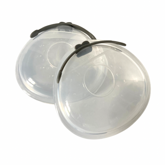 Two clear silicone milk shells with a black clip and a case, designed for catching breast milk during feeding.
